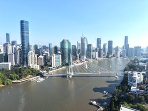 Stunning aerial shot of Brisbane city skyline over the Brisbane River on a sunny day.